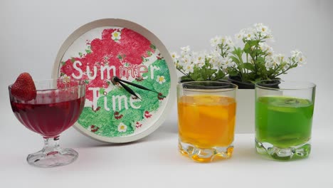 clock,  box with flowers and gelatin dessert in a glass ware stand on a white table,  time lapse