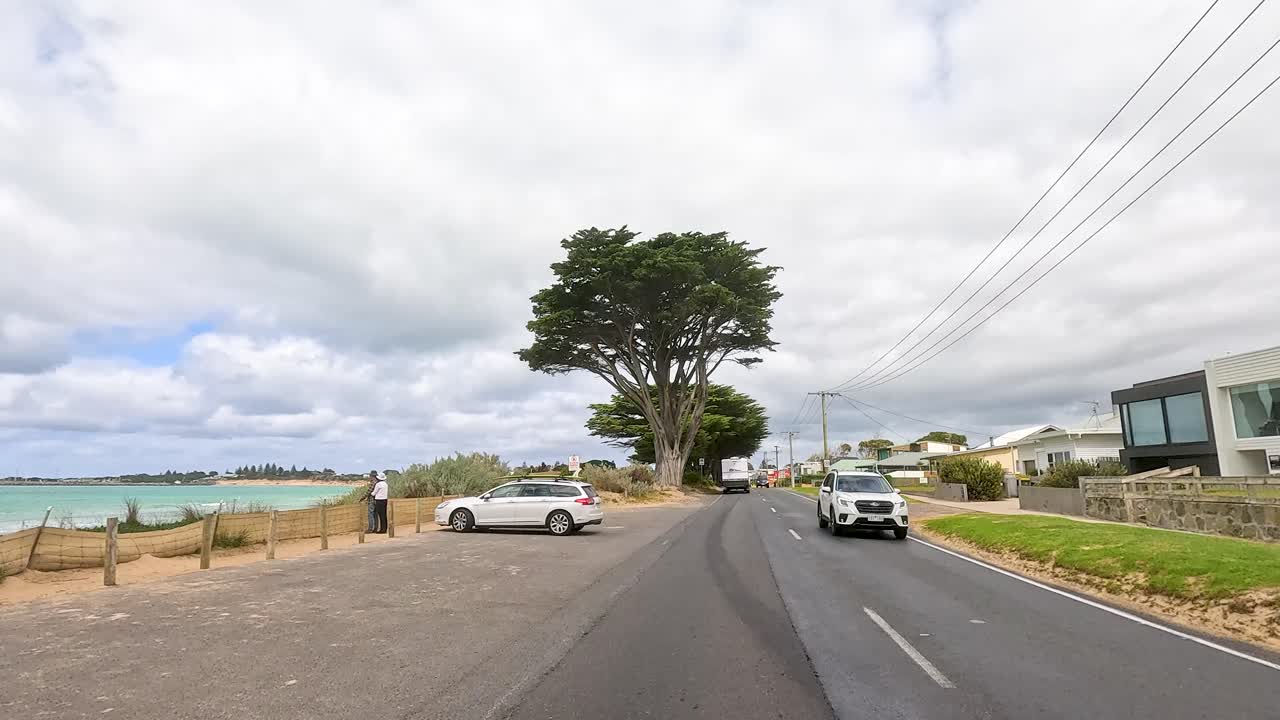 A 45-second drive showcasing coastal roads, lush trees, and residential areas under cloudy skies