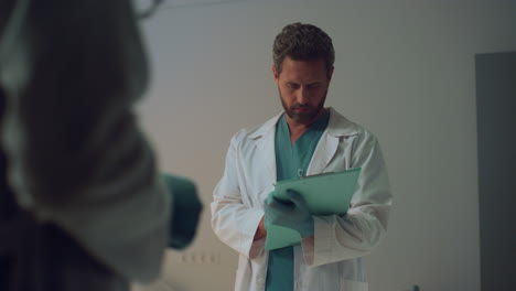 doctor holding clipboard noting information. scheduled appointment in hospital.