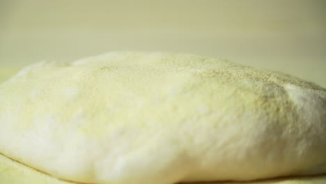 semola flour gets evenly distributed on top of the pizza dough before it gets stretched