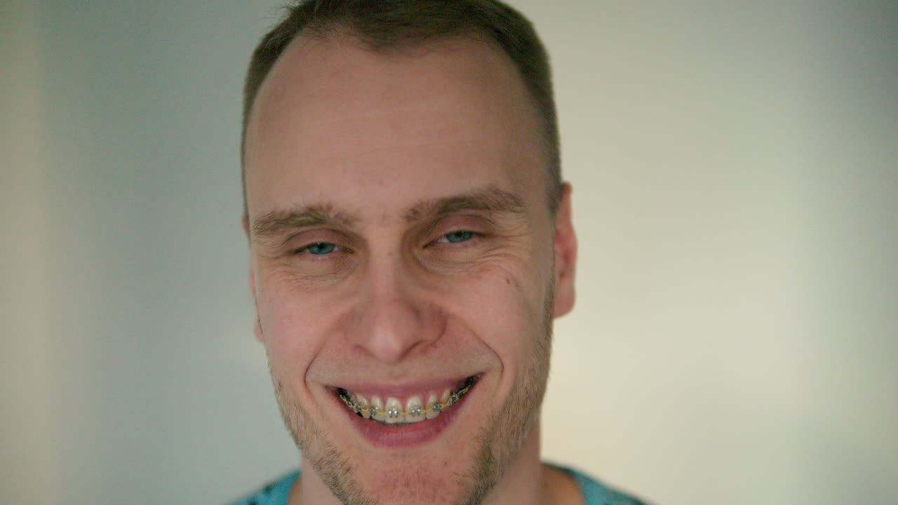 el hombre mira a la cámara con cara seria y luego se echa a reír