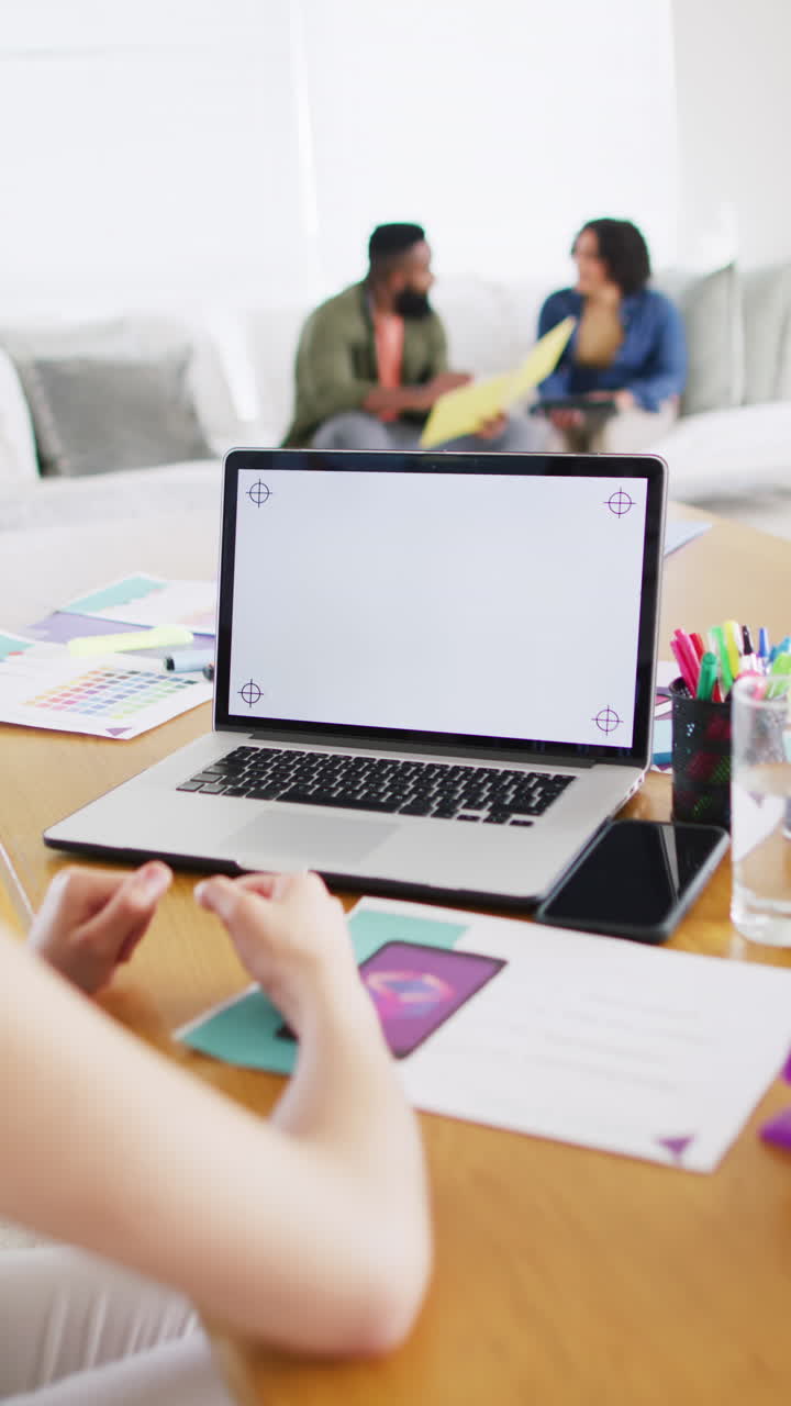 Vertical video of diverse woman making laptop video call, copy space on screen, slow motion