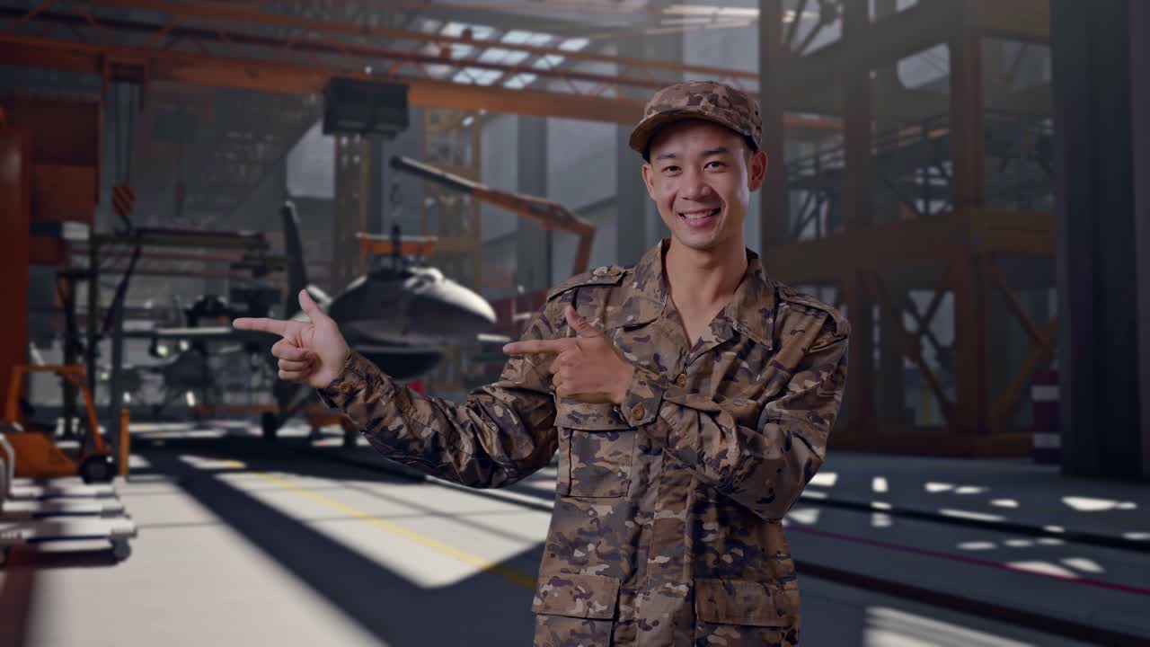 Soldato sorridente in uniforme mimetica che indica un hangar di aeromobili