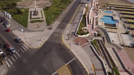 Aerial-tracking-shot-of-person-riding-bike-on-bicycle-lane-along-beach-during-hot-summer-day-in-city-of-Mar-del-Plata