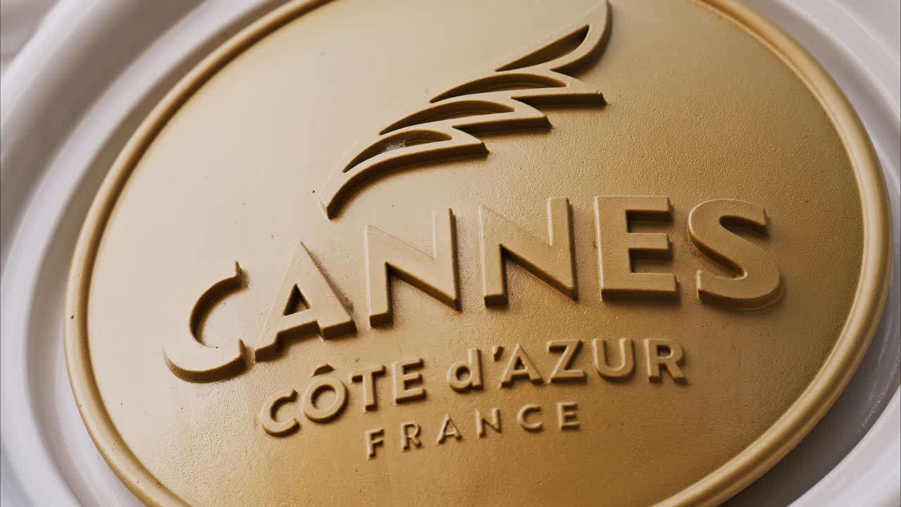 Close up of a white, rotating signboard with the words Cannes in France