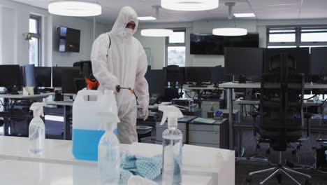 health worker wearing protective clothes cleaning the office using disinfectant