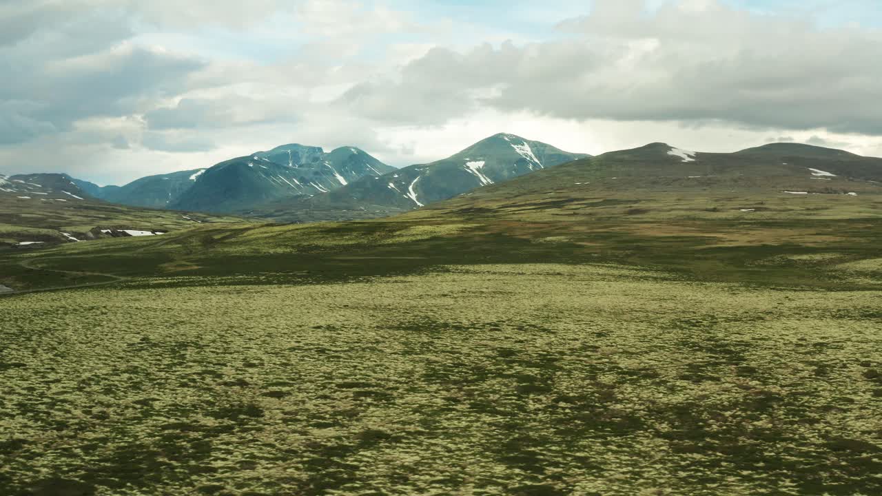 노르웨이의 론데인 국립 공원 (rondane national park) 의 초원 평야와 산 위에서 공중 트럭을 운반합니다.