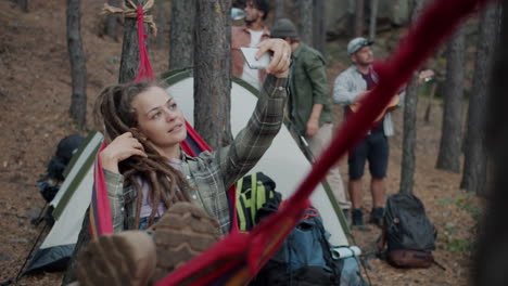 friends taking a selfie in a forest hammock