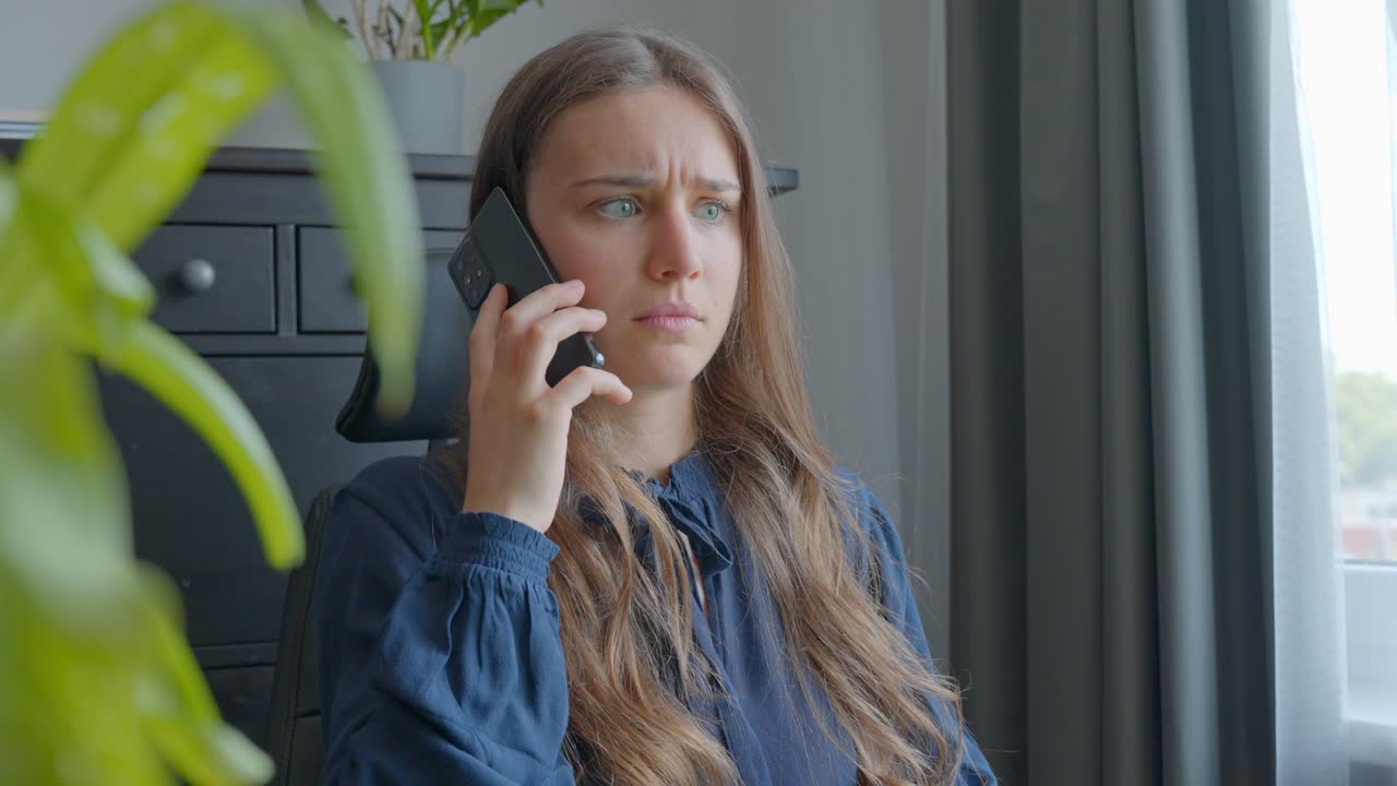 Young caucasian woman on a phone call looking stressed, worried and talking back