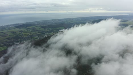 aerial view of mountain peak in clouds against blue sky