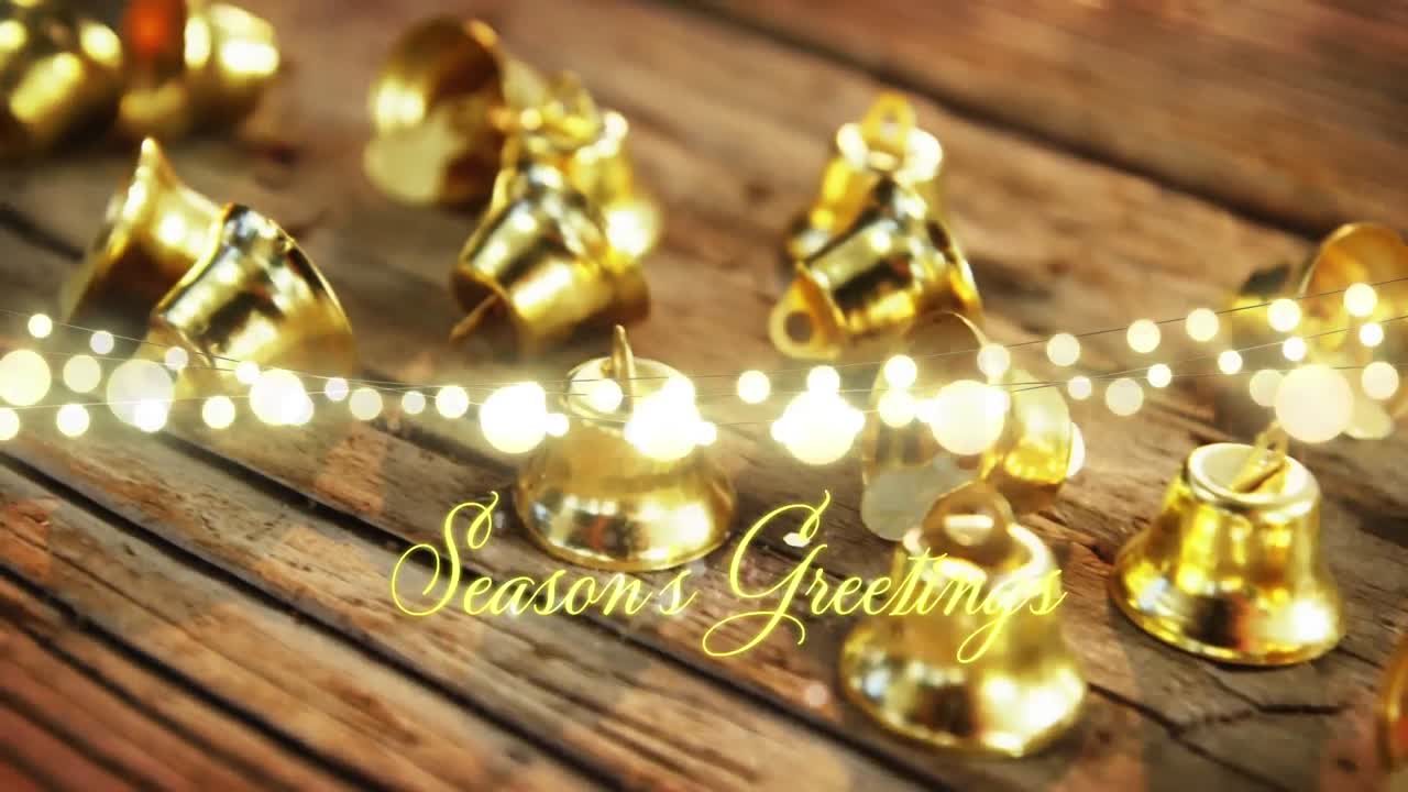 Animation of text, season's greetings, in yellow, over string lights and christmas bell decorations