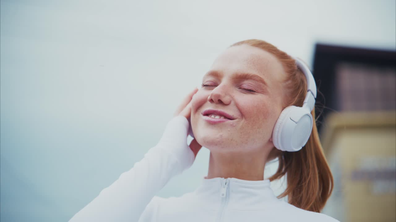 Redhead woman with headphones listening to music