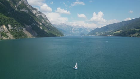 Yate-Solitario-Navegando-En-Aguas-Tranquilas-Del-Lago-Suiza,-Vista-Aérea