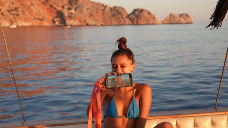 mujer tomando una selfie en un barco durante la puesta de sol