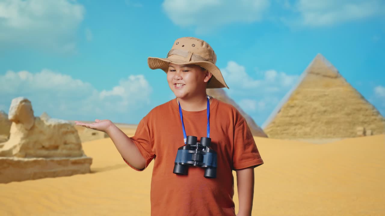 Asian Boy With A Hat And Binoculars Smiling And Pointing To Side While Traveling In Giza Pyramid. Boy Researcher Examines Something, Travel Tourism Adventure, Close Up