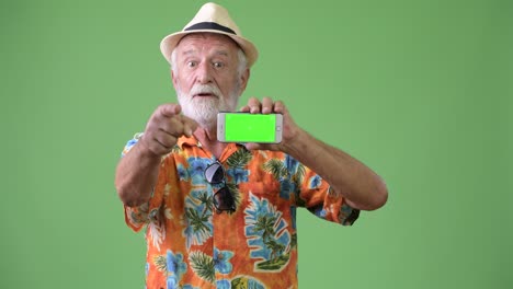 hombre turista barbudo y guapo listo para las vacaciones contra un fondo verde