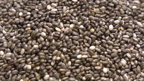 macro shot of chia seeds being poured into a pile that is building up