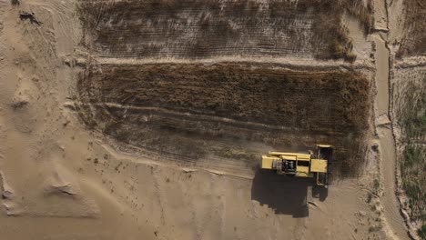 Birds-Eye-Aerial-View-Of-Yellow-Combine-Harvester-Working-In-Punjab-Field-In-Pakistan