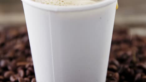 coffee beans falling in disposable cup