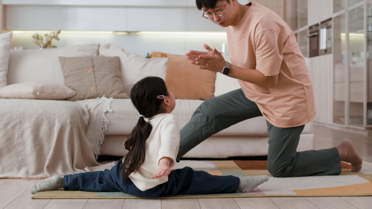 Father teaching daughter stretching exercises at home