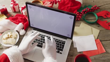 santa claus usando una computadora portátil con espacio de copia sobre las decoraciones de navidad