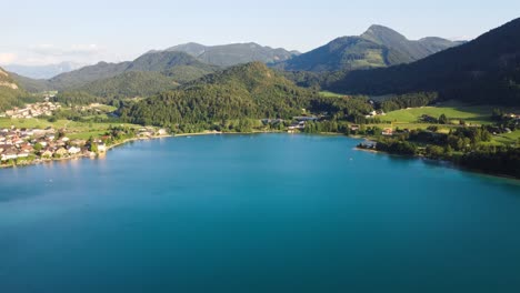 flyover aerial of light blue lake in austria, fuschl am see, summer sunny day