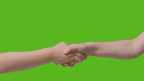 Close-Up-Of-Two-Young-Children-Shaking-Hands-Against-Green-Screen