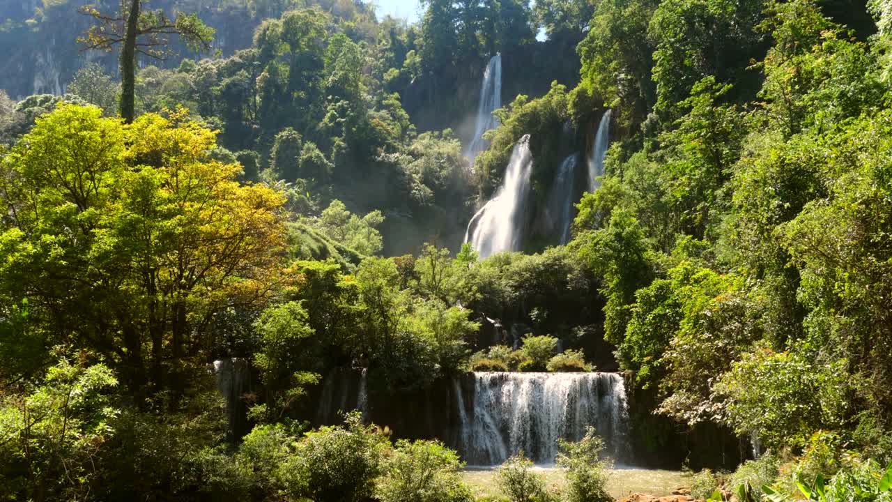 hermosa cascada en el verde bosque tropical. selva de montaña con cascadas de piedra caliza. famosa cascada más grande y más alta de tailandia. poderoso arroyo de agua blanca en furia. cámara lenta