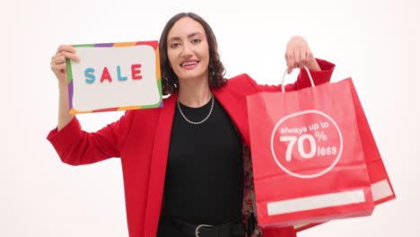 woman excitedly showcasing 'sale' sign and shopping bags with discounts