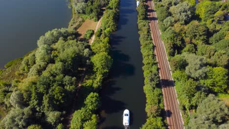 drone-shot-of-a-boat-sailing-in-a-canal-during-the-day-in-Norwich,-England