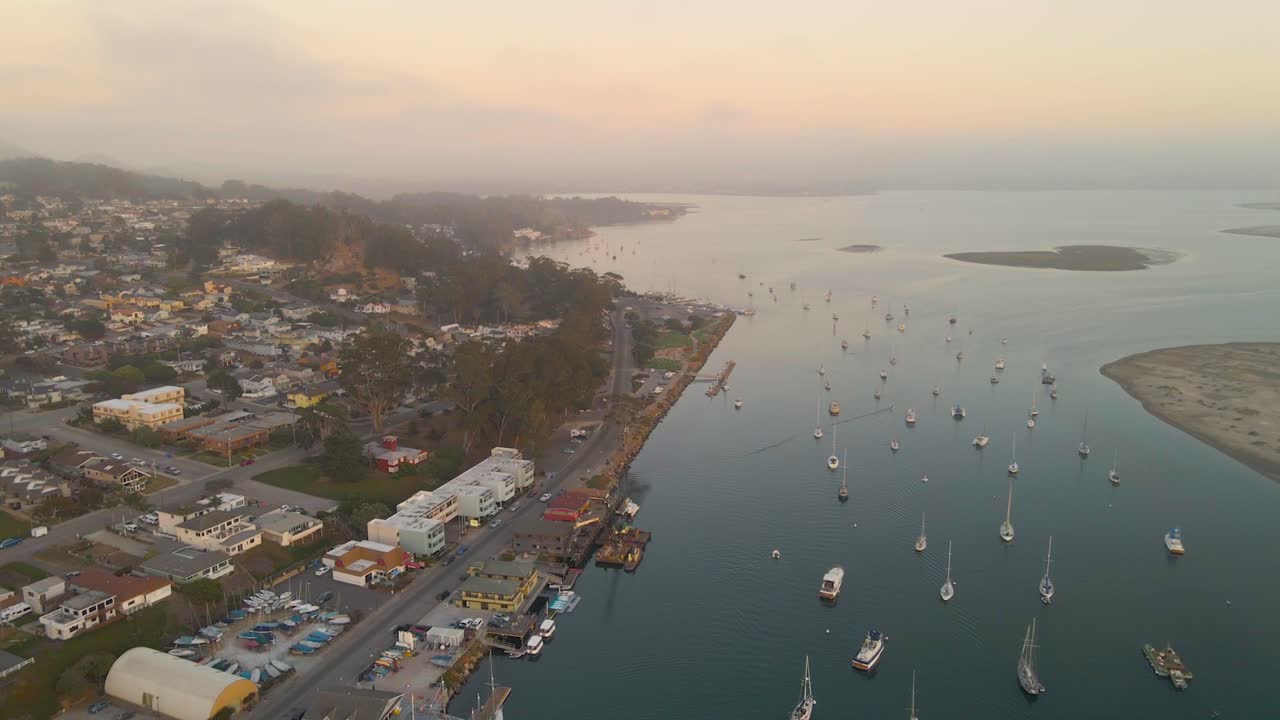 Aerial video or Morro Bay California Harbor while flying at sunset
