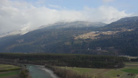 wide view of tyrolean valley with green forests and snow-dusted peaks.