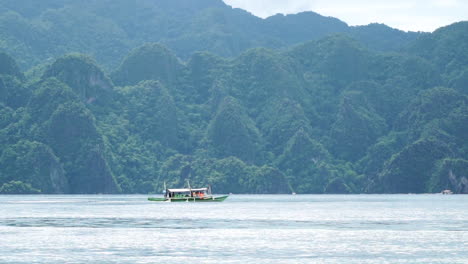 tiro largo de un barco de pasajeros en coron palawan, al lado de las montañas