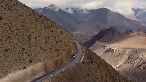 Disparo-De-Dron-De-Una-Furgoneta-Blanca-Conduciendo-Por-La-Carretera-De-Crucero-En-El-Camino-De-Mustang-Nepal