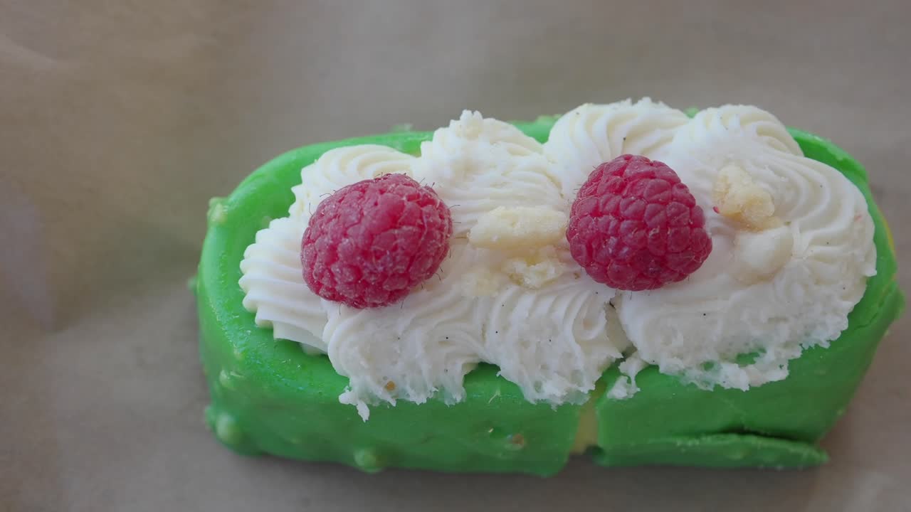 Close-up of a Green Cake with Raspberries and White Frosting