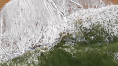 Ocean-waves-washing-up-on-the-shore-of-Paradise-Beach-in-Carvoeiro,-Algarve,-Portugal---Rocket-Aerial-shot