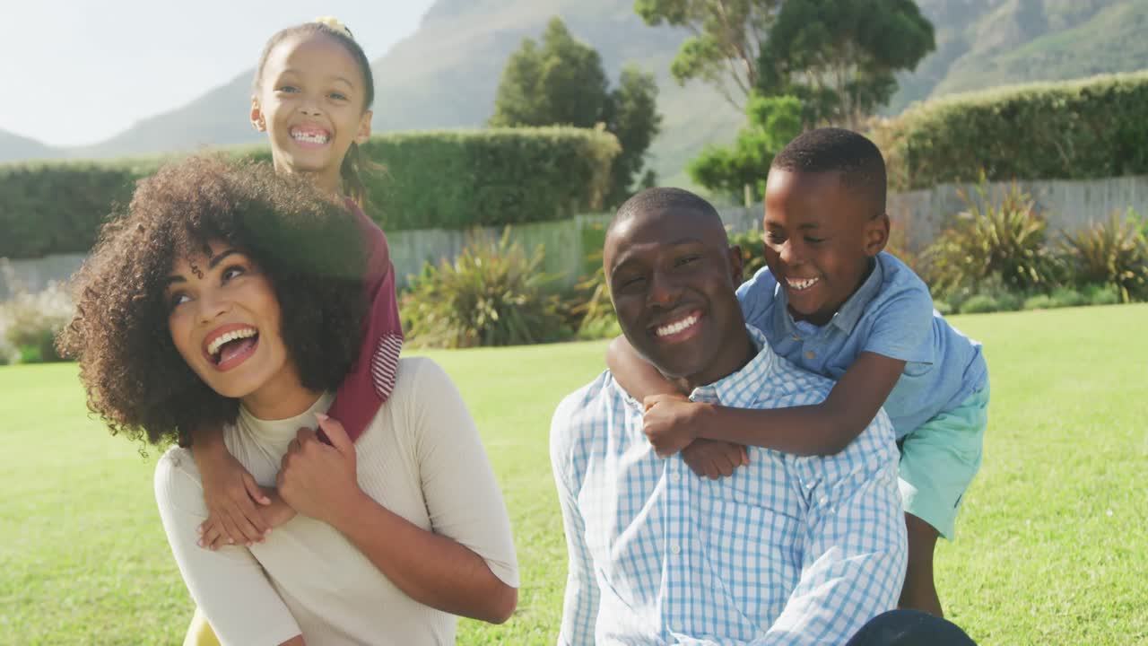 Video of happy african american family spending time together in the garden