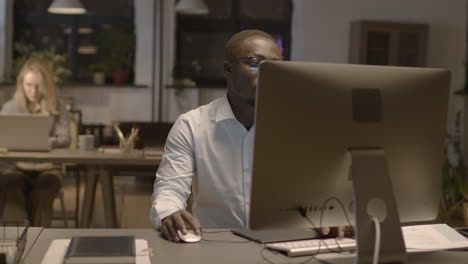 serious american employee working on computer in the office