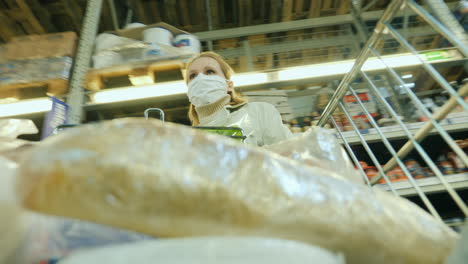 shopper at grocery store wears protective mask shopping during coronavirus pandemic