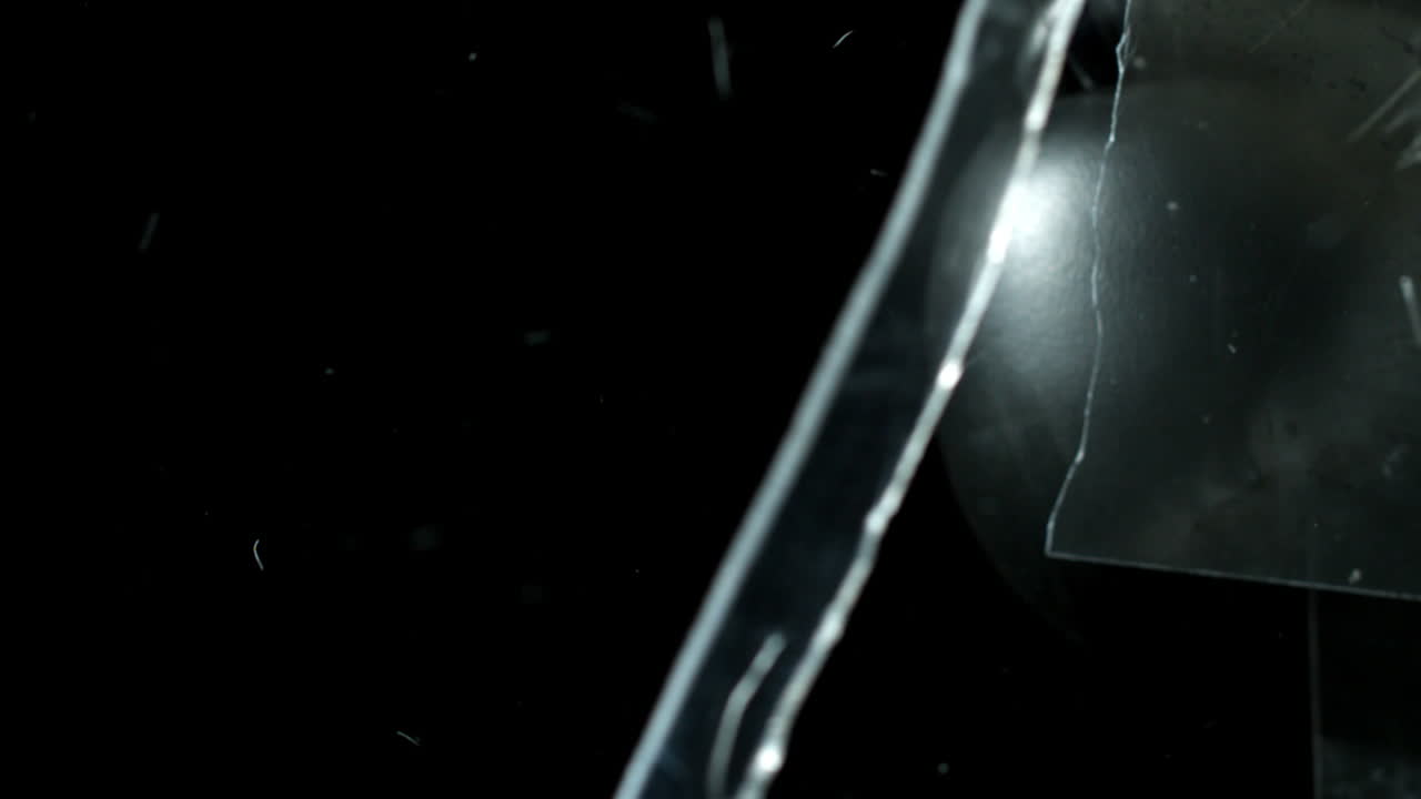 vidrio que se rompe en fragmentos sobre un fondo negro