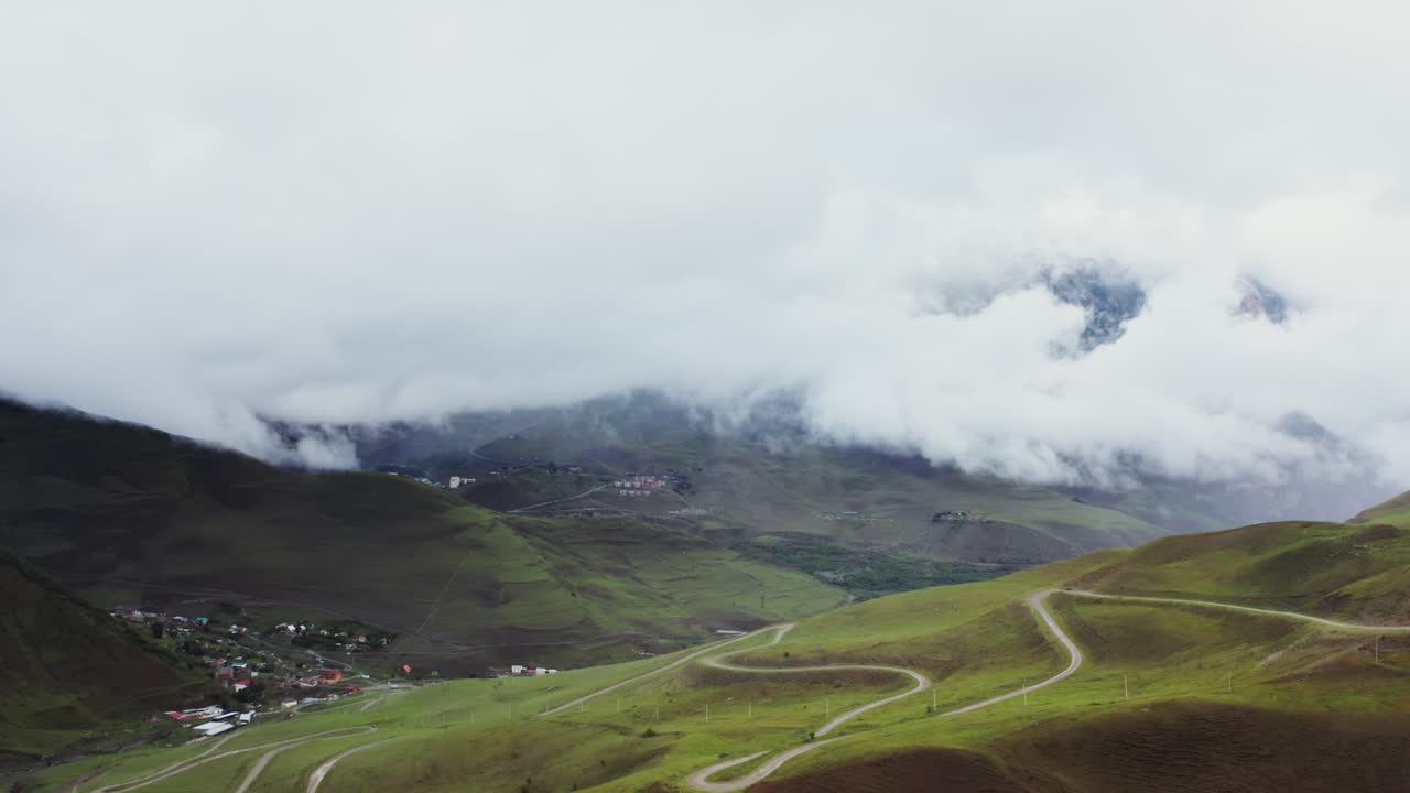 paisaje montañoso brumoso con carreteras sinuosas
