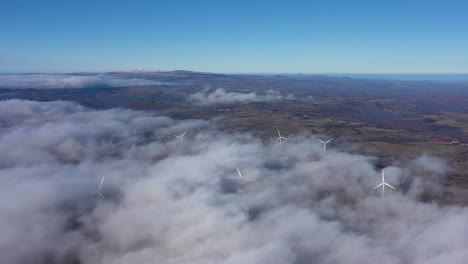 panoramic view of wind turbines in clouds massif central mountains france