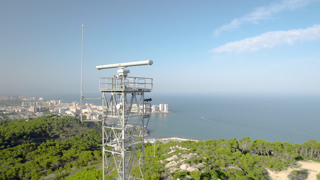 스페인 오로페사 델 마르 해안에서 푸른 지중해를 스크린하는 언덕 꼭대기에 있는 회전하는 해상 레이더의 4k  ⁇ 도 항공 클로즈업 뷰