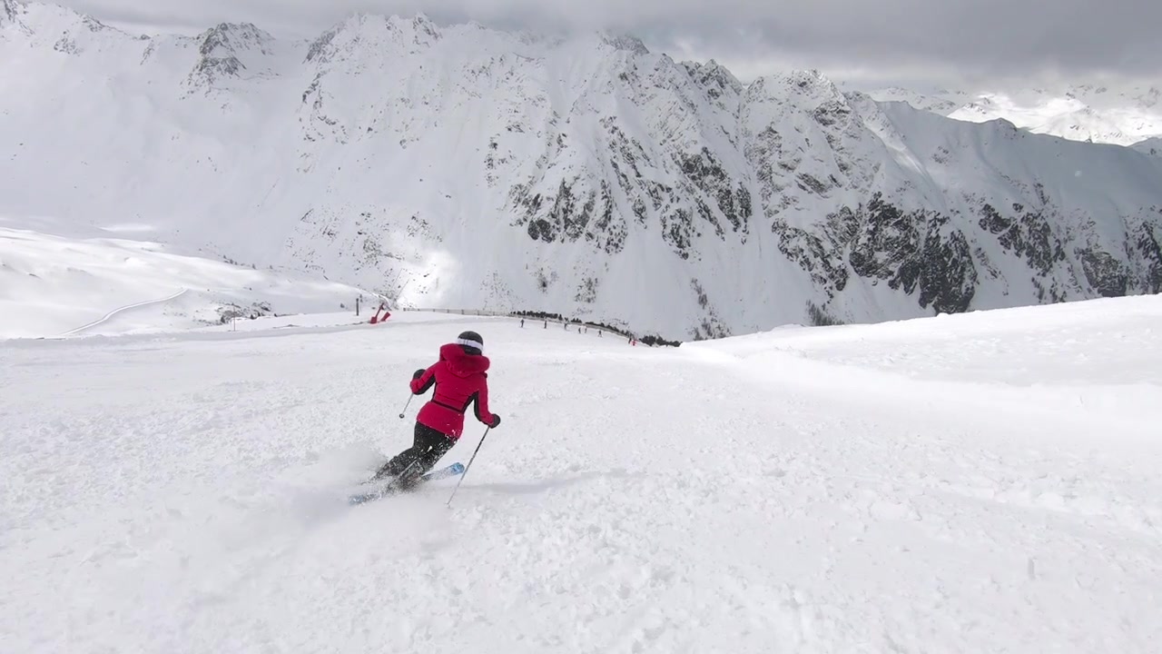 Girl skiing beautiful sporty turns in a great rythm. The tyrolean alps as a perfect playground