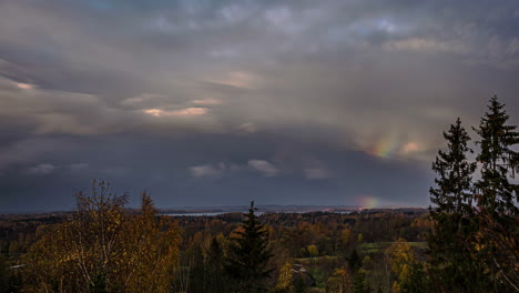 Lapso-De-Tiempo-Moviendo-Nubes,-Arco-Iris-En-El-Cielo-En-El-Bosque-Rural-De-Riga,-Letonia