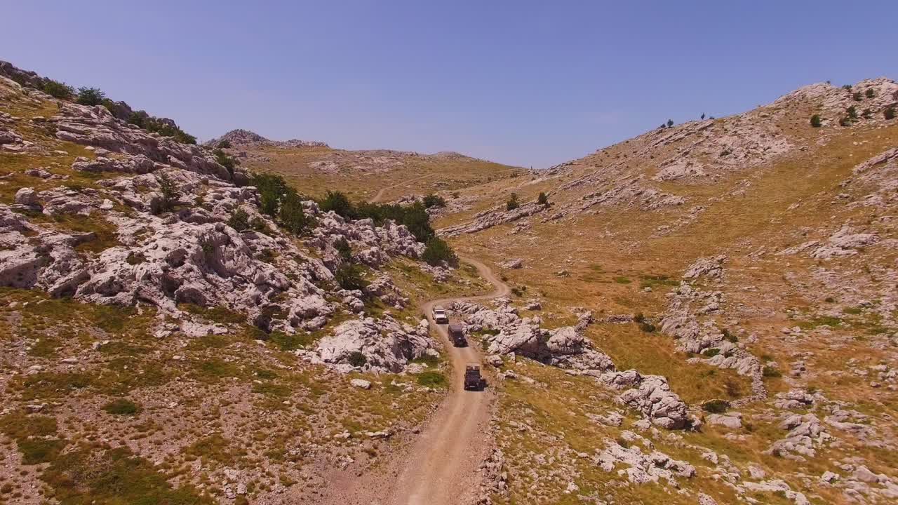 coches todoterreno circulando por montañas y rocas, tierra seca