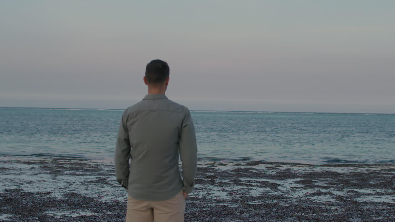 Man Contemplating the Ocean at Sunset