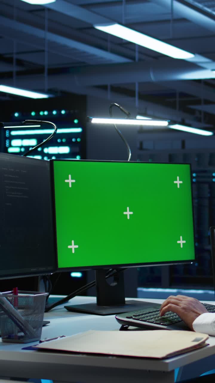 Person, der skriver på tastatur med grøn skærm i datacenter
