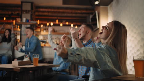 a group of men and women in a pub together cheer for their national team at the world cup in football basketball hockey. celebrate the goal scored the puck. celebrate a beaten penalty