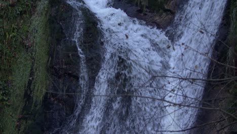 Winterwasserfall-Mit-Zweigen-Im-Vordergrund---Slomo